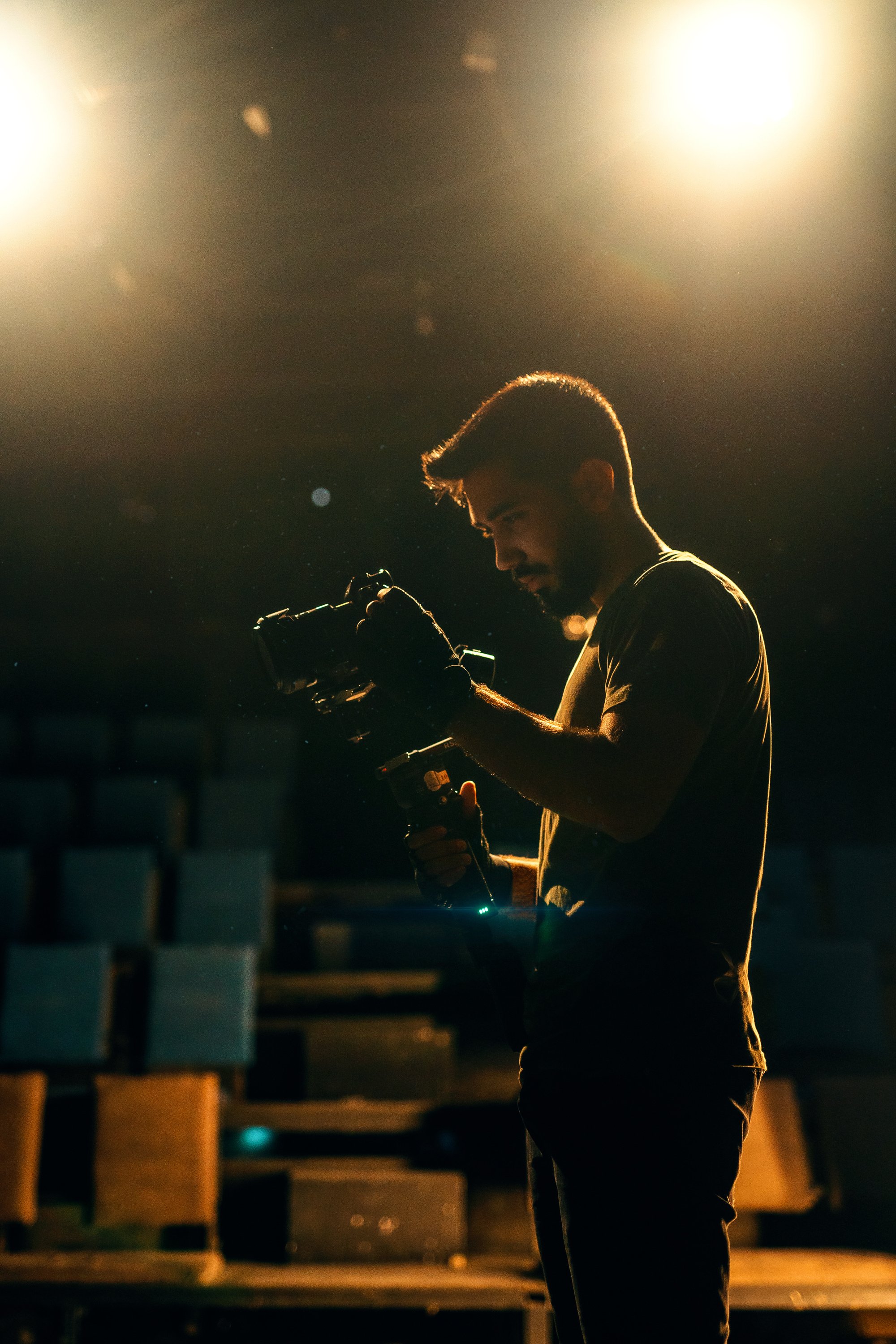 A Man Holding a Camera inside a Theater